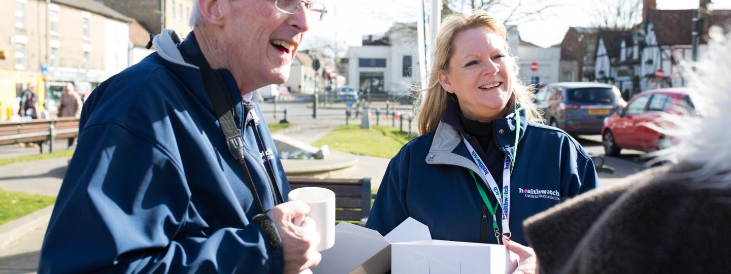 To Healthwatch volunteers speaking to someone at an outdoor event